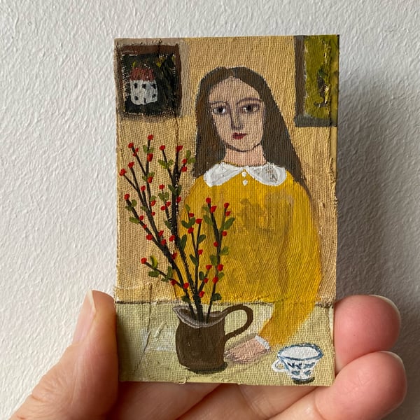 Image of Woman in yellow at a table - tiny portrait 