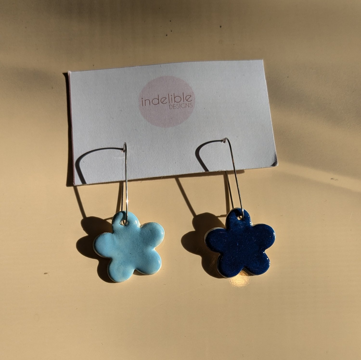 Image of baby blue and dark blue daisy asymmetrical earrings