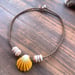 Image of Hawaiian sunrise shell necklace with golden pukas and a locking seaglass clasp