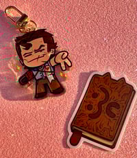 Mini Ash Charm + Necronyamicon Sticker bundle!