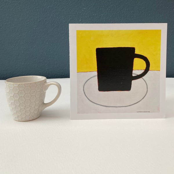 Image of Black Cup on Yellow card