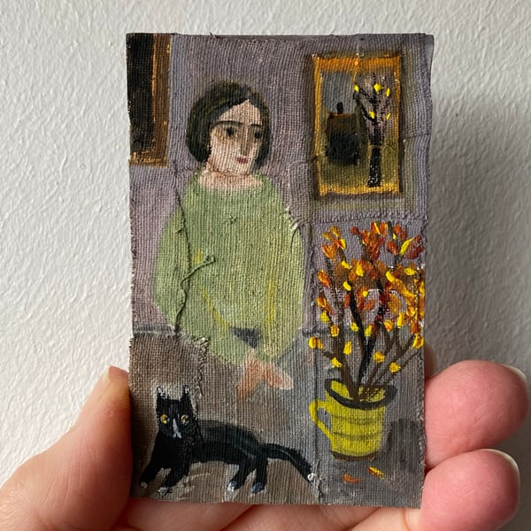 Image of Woman in pale green with cat on table - tiny painting 
