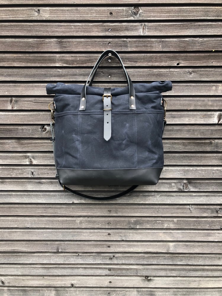 Image of Black waxed canvas carryall with luggage handle attachment leather handles and shoul