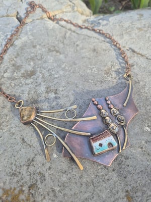 Necklace with a house under a mallow flower
