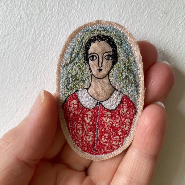 Image of woman in scarlet, in a garden - embroidery brooch