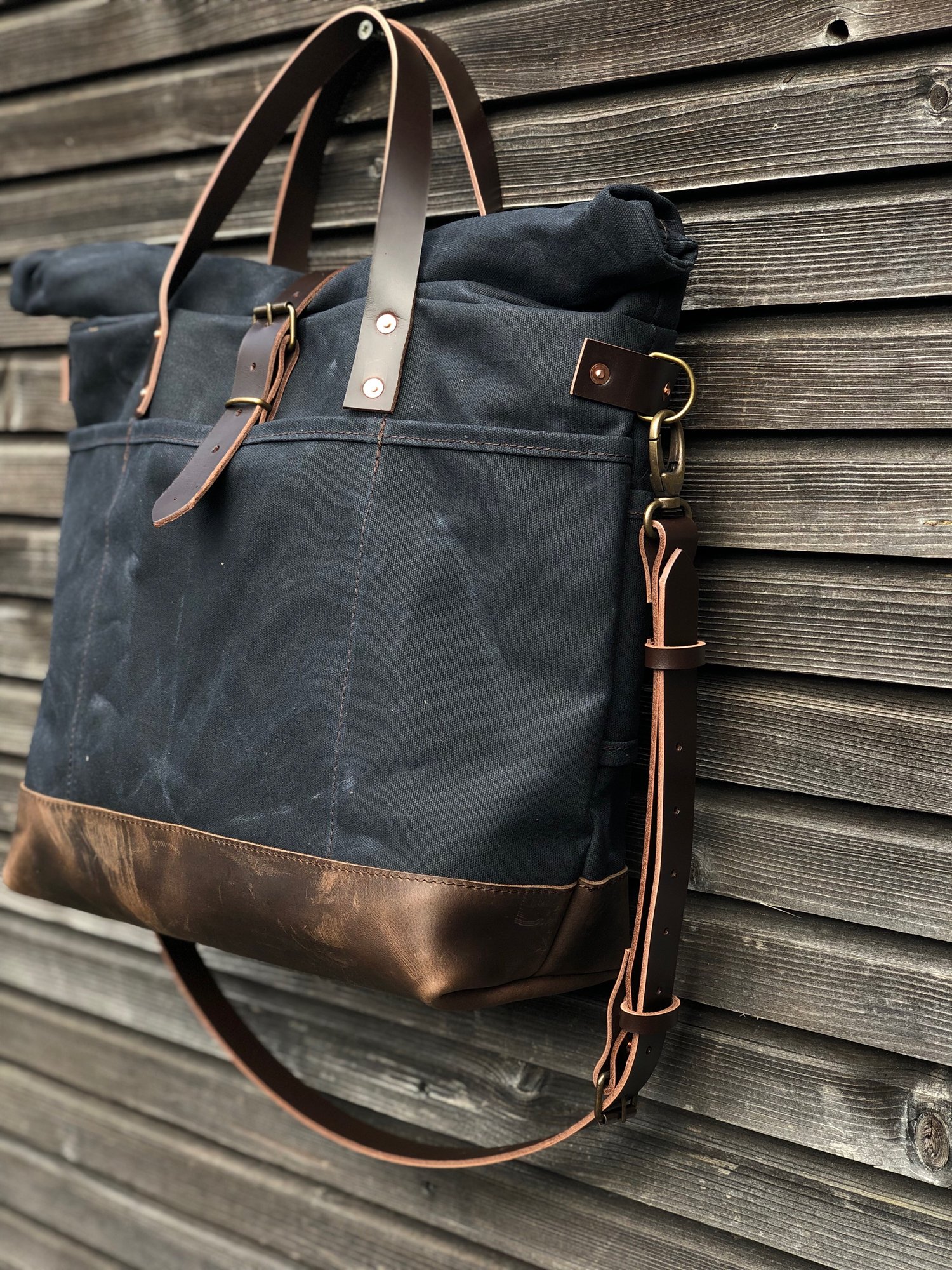 Image of Black waxed canvas roll to close top tote bag with luggage handle attachment 
