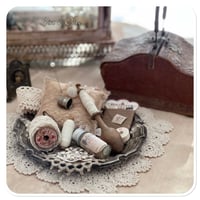 Image 1 of Vintage style tattered square pin cushion sitting on a tray full of sewing notions