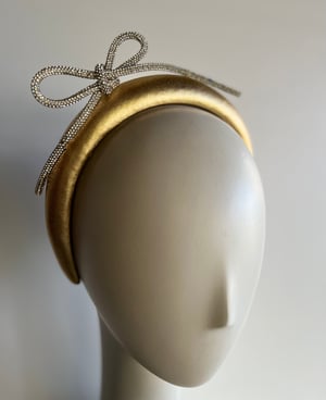 Image of Gold padded headband w diamanté bow. 