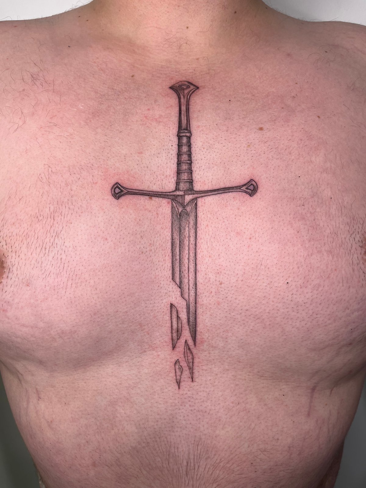 Sword tattoo placed on the chest, micro-realistic